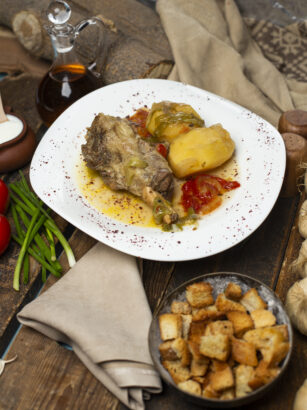 meat-stew-with-potatoes-oily-broth-white-plate-with-bread-crackers
