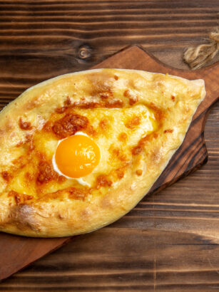 top-view-baked-bread-with-cooked-egg-wooden-surface-bread-dough-bun-breakfast