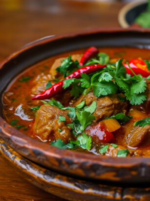 traditional-georgian-veal-dish-chashushuli-stewed-meat-with-onions-and-peppers-on-a-wooden-table-with-copy-space-idea-for-menu-design-or-food-blog