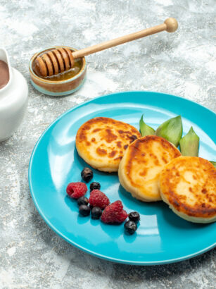 front-view-delicious-muffins-with-berries-light-table